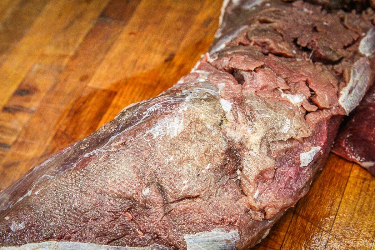 Freezer burn on thawed meat shows up as gray or brown on the surface.