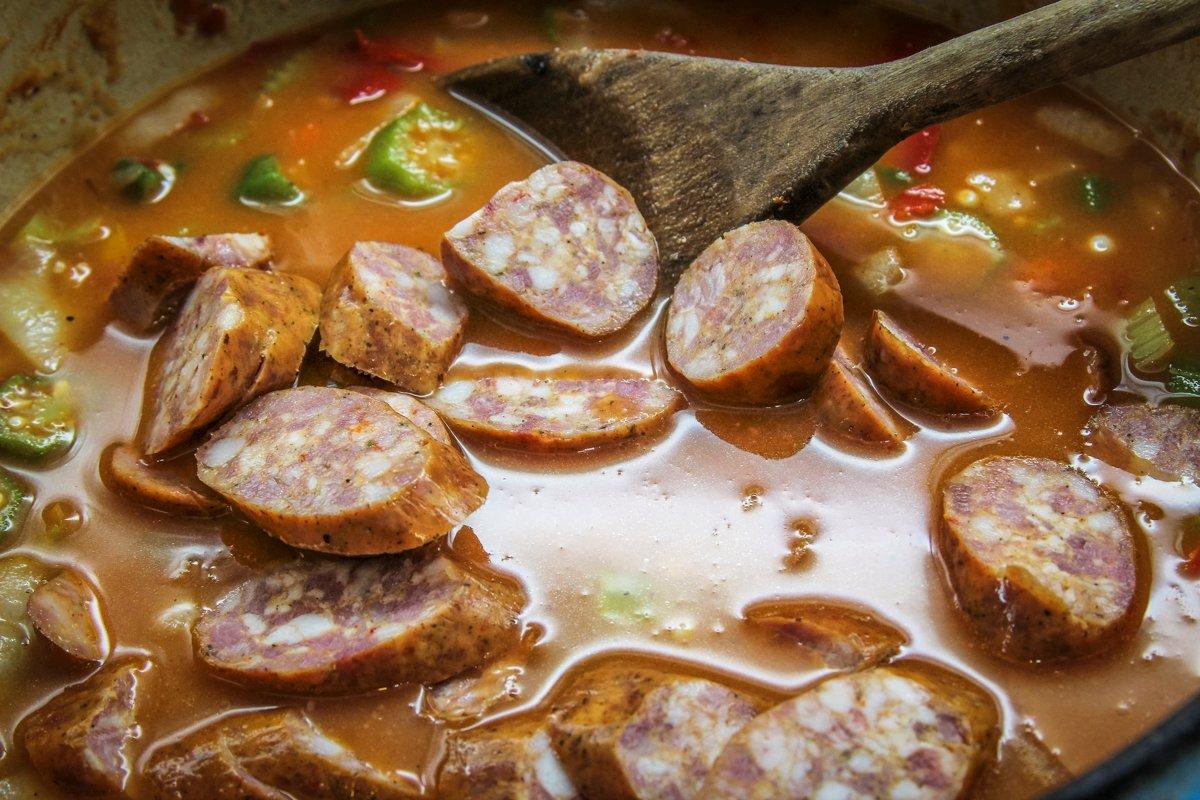 Add the stock and the sausage, then simmer.