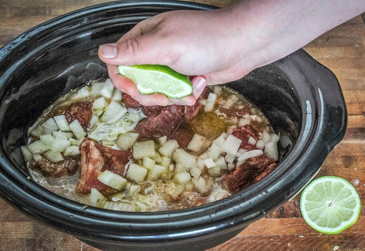 Squeeze fresh lime over the pork in the slow cooker.