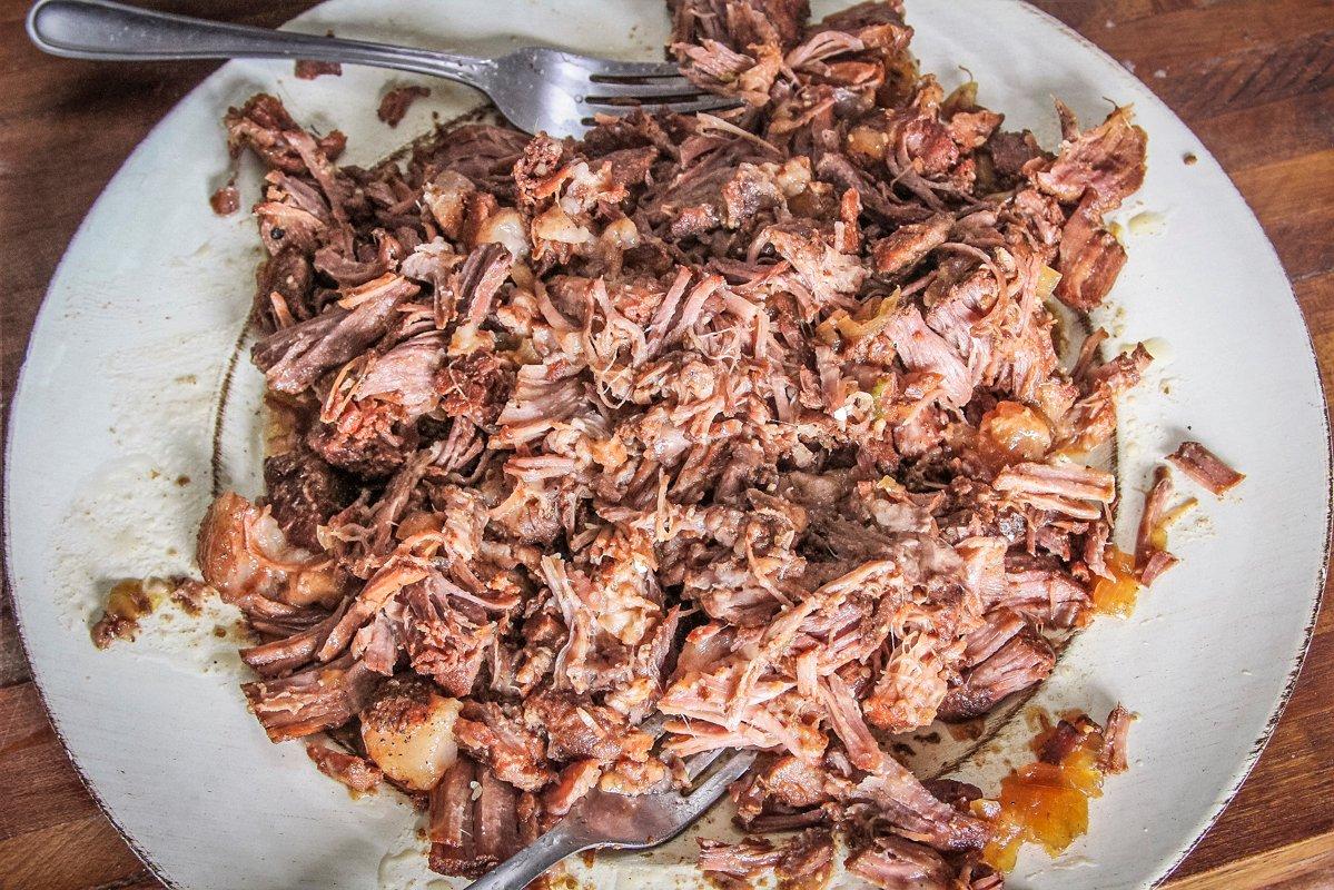 Once the pork is ready, remove it from the slow cooker and shred.