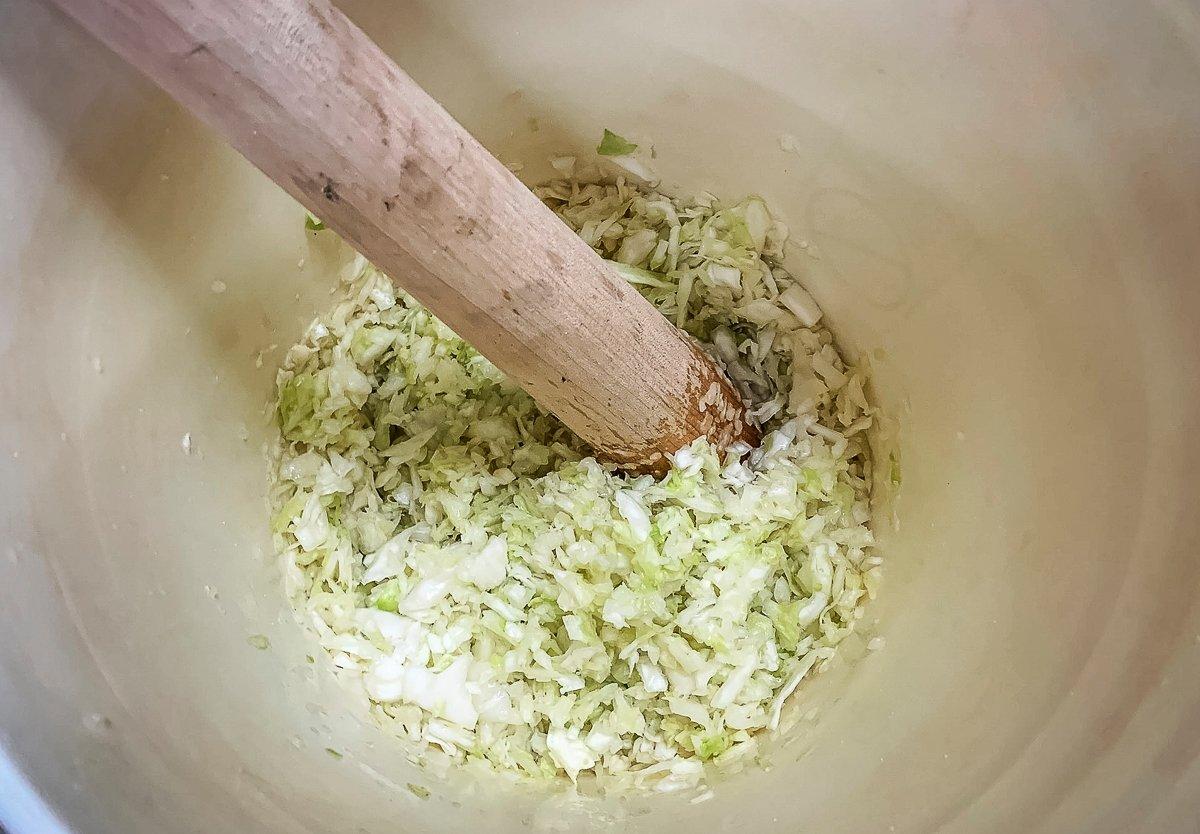 Smash the salted, shredded cabbage in the bucket with a cleaned wooden dowel or baseball bat. 