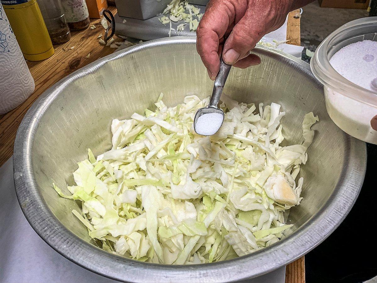 Shred the cabbage with a sharp knife or a meat slicer, then salt before adding it to the bucket.