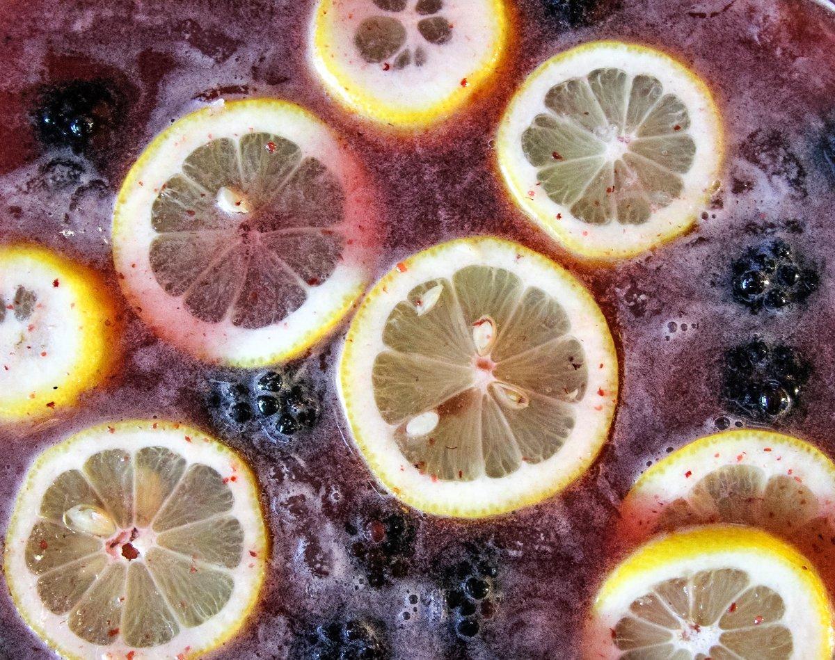 Float lemon slices and blackberries on the surface of the punch as garnish.