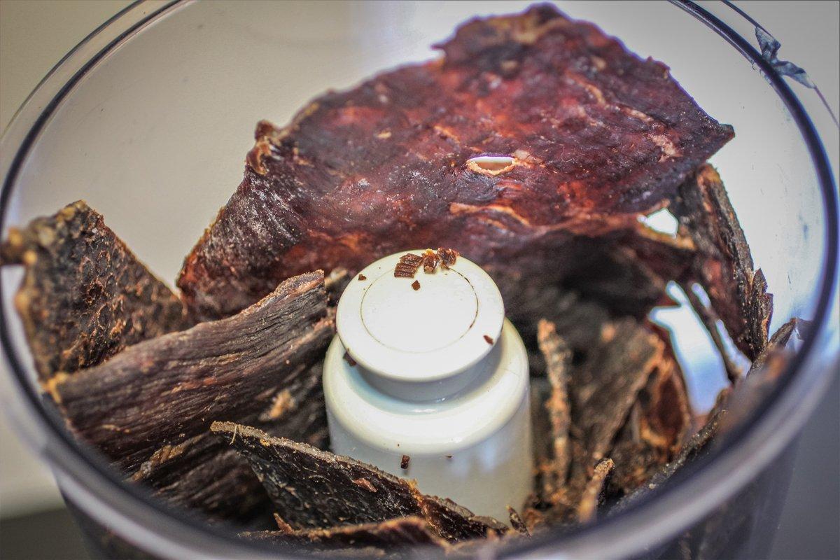 Start by adding dry jerky to a food processor and pulverizing it. 