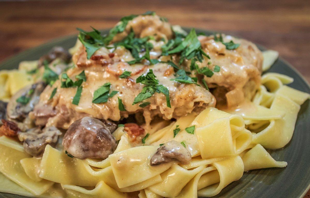 Serve the dish over egg noodles and garnish with diced flat-leafed parsley.