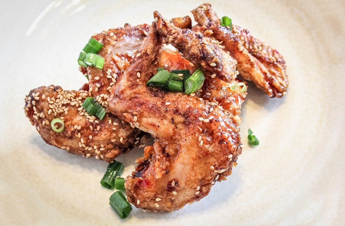 Top the sauced rabbit with the toasted sesame seeds and chopped green onions.