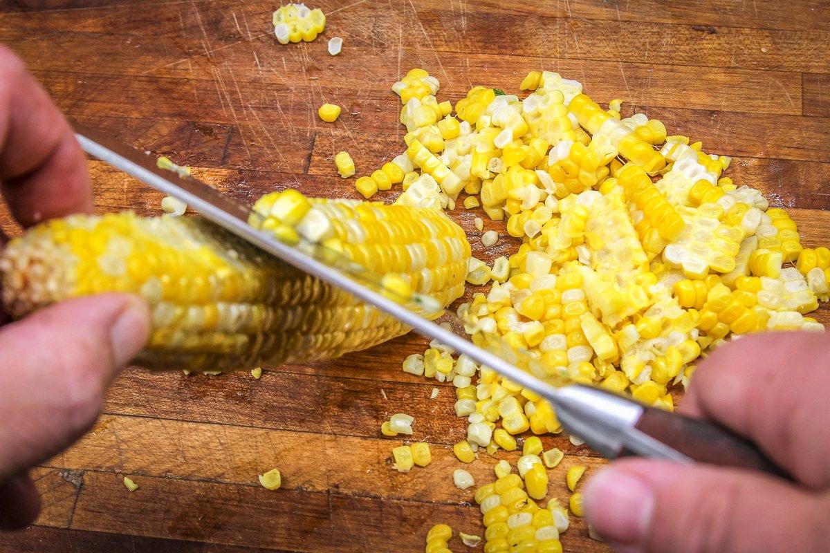 Use a sharp knife to slice the grilled corn kernels from the cob.