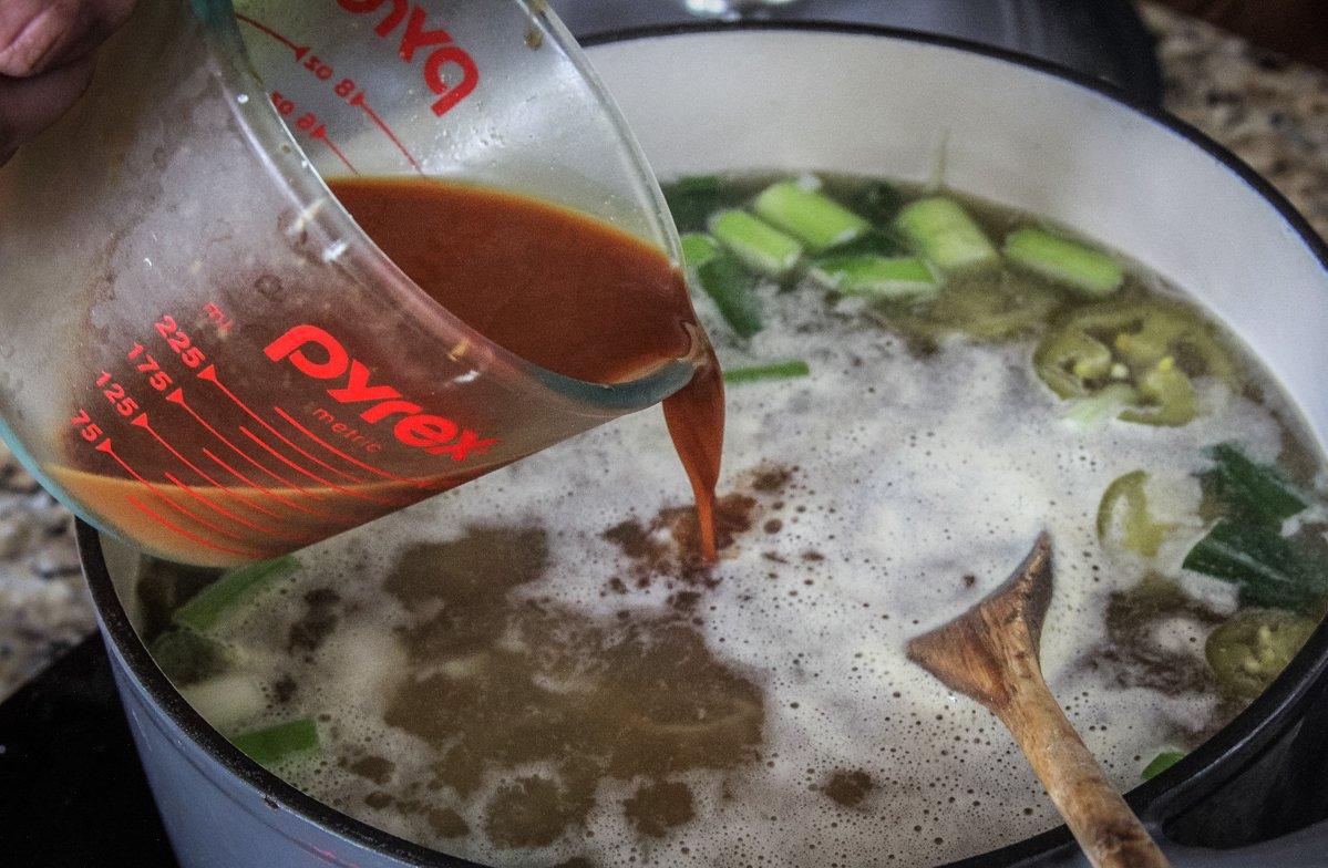 Pour in the soy and corn starch slurry to thicken the soup base.