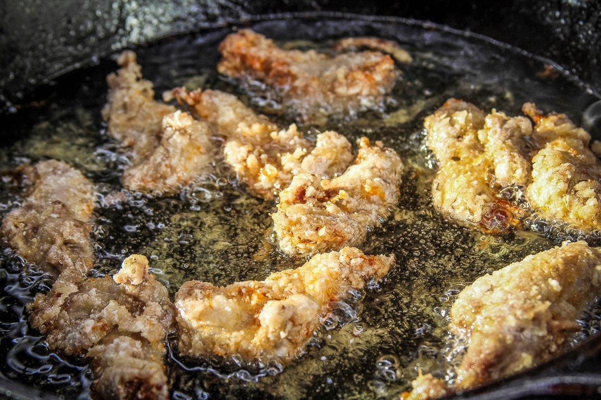 Season the legs with white pepper, then coat with cornstarch and pan-fry until golden, crispy brown.