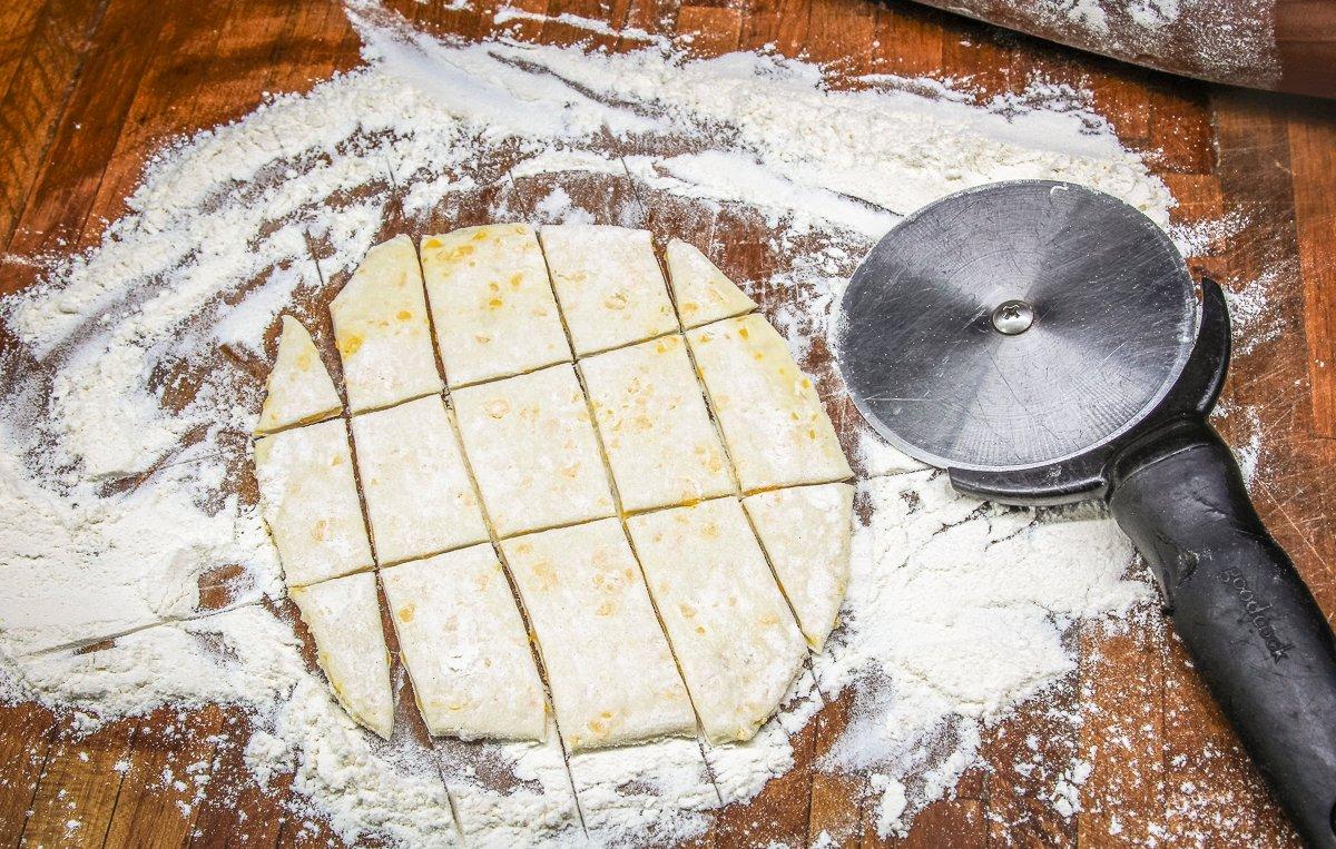 Roll the biscuits flat on a floured surface, then cut into dumpling-sized strips.