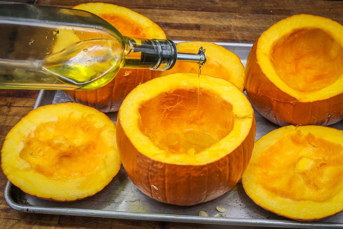 Hollow out the pumpkin shells and drizzle with olive oil before roasting.
