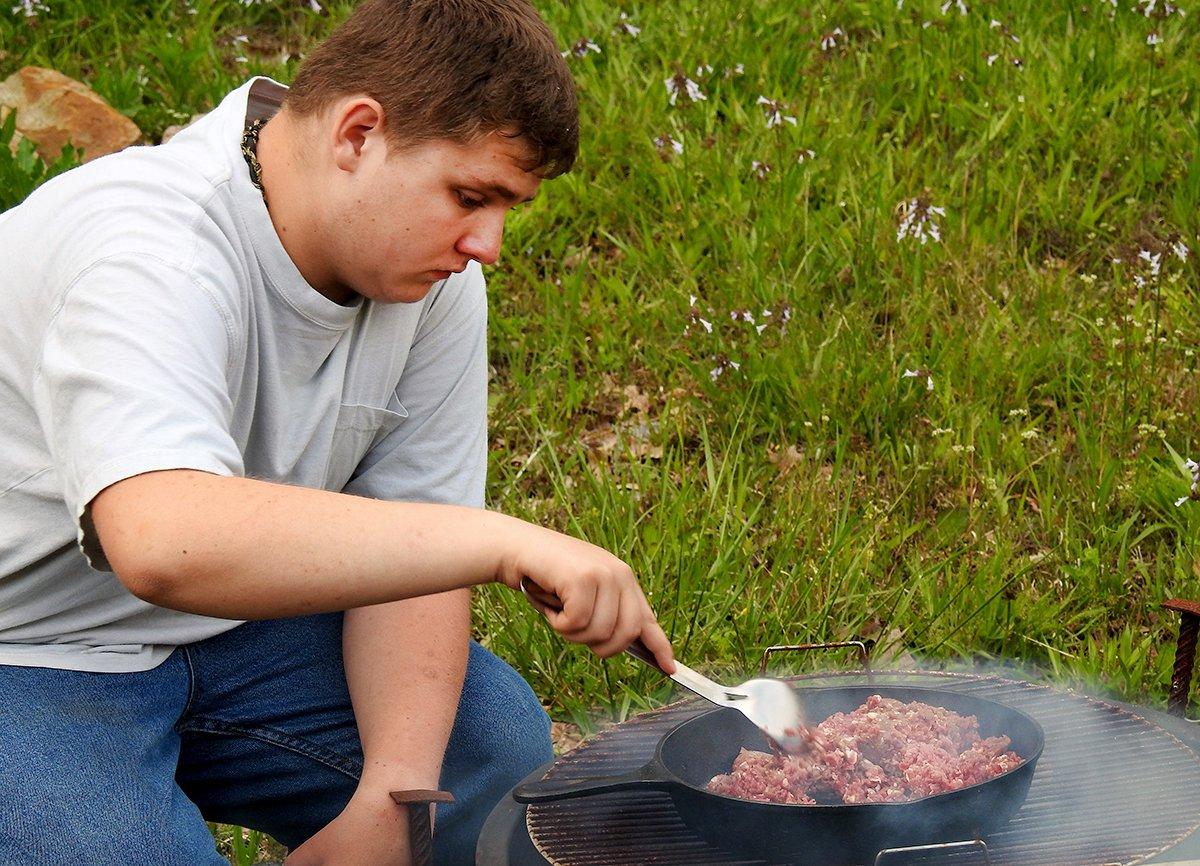 Brown the ground venison over the firepit or camp stove, then add the taco seasoning.