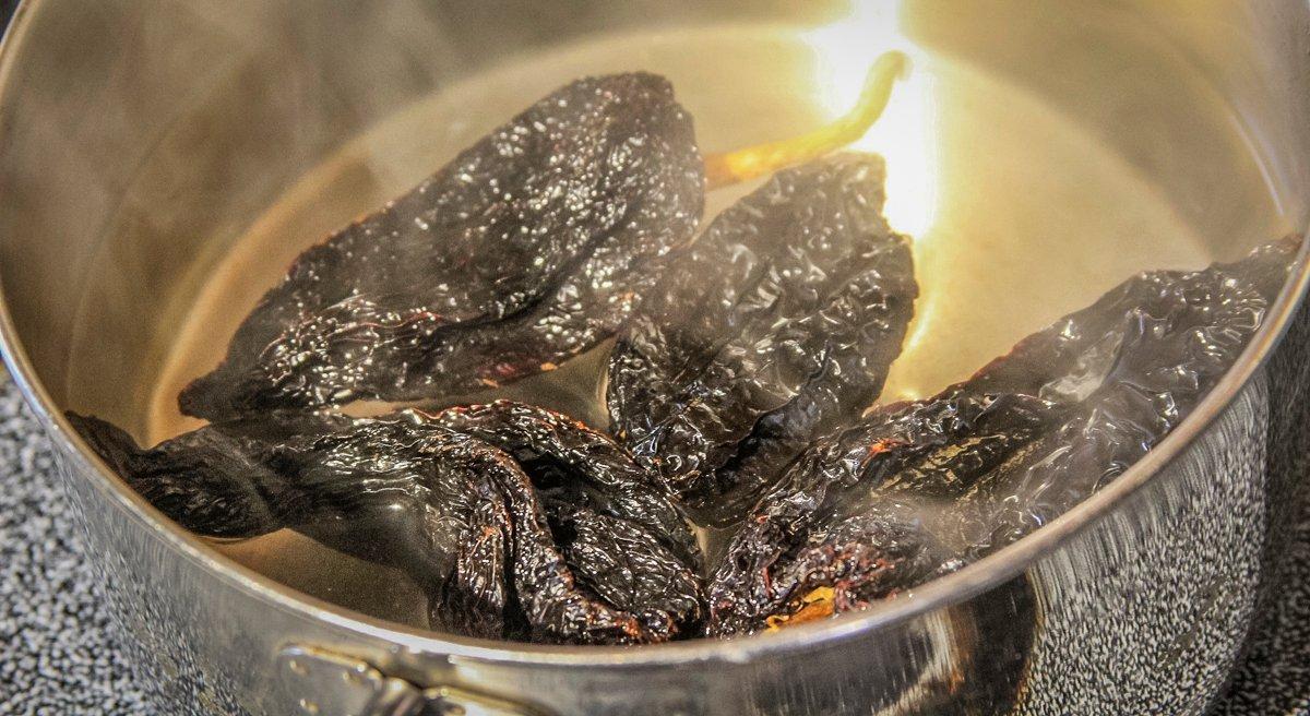 Soak the dried ancho chili peppers in hot water until soft.