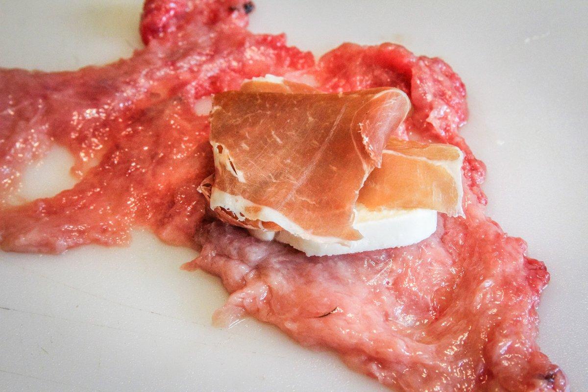 Lay a slice of prosciutto and a slice of mozzarella on each flattened slice. 