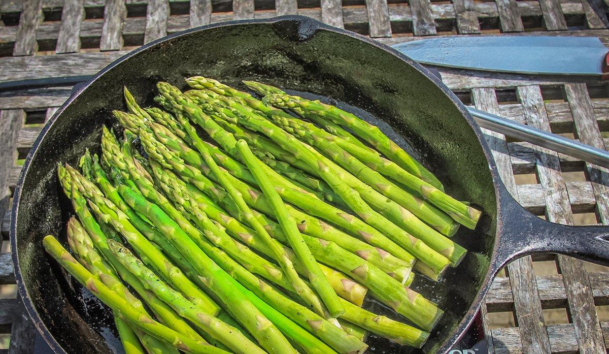 After the bacon cooks, add the asparagus to the skillet and cook for a few minutes to soften.