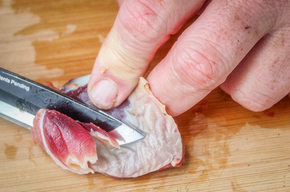 Using a sharp knife, slice away the grinding plates and the heavy gray muscle from the center of the gizzard.