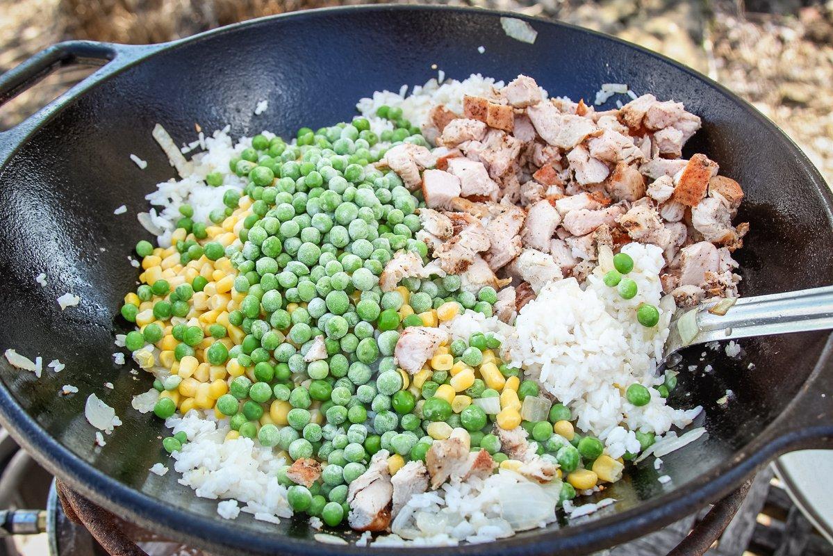 Stir fry until the frozen peas and corn are cooked through before adding the egg.