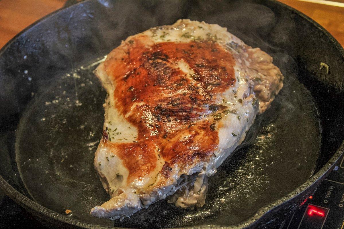 Sear the cooked turkey breast in duck fat in a cast iron skillet.