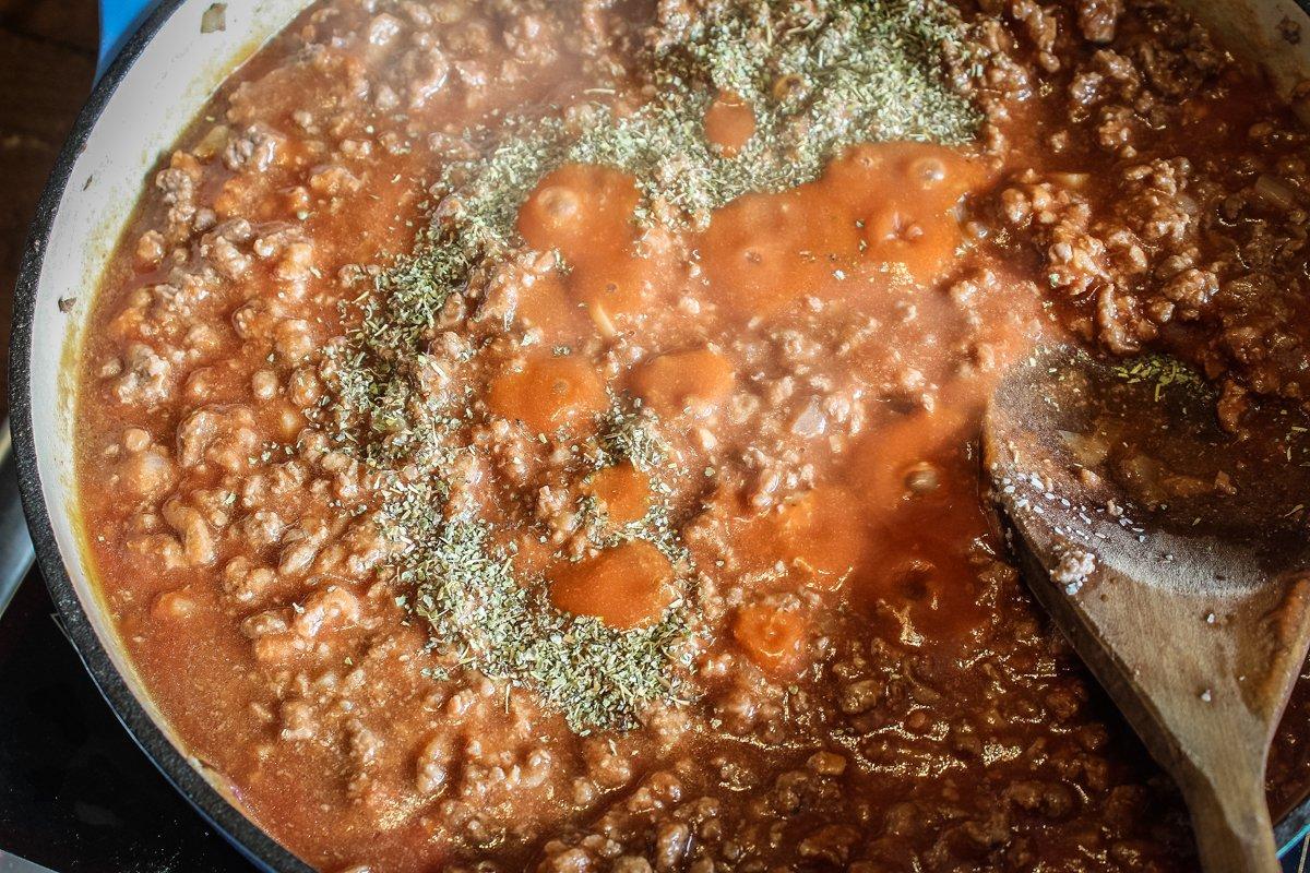 Add the sauce and seasoning to the browned ground venison and simmer.