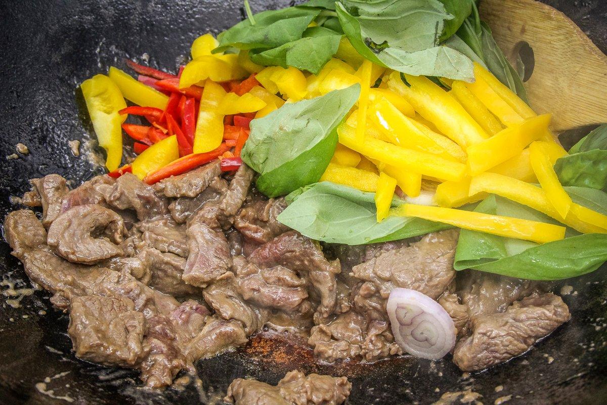 Brown the meat then move it to the side of the wok while the vegetables stir fry.