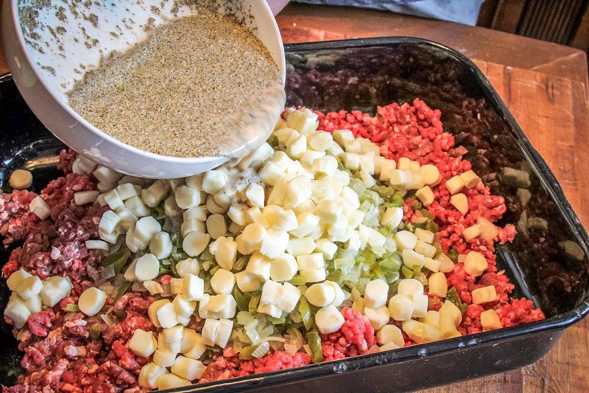 Blend peppers, onions, cheese chunks and seasoned liquid into the meat.