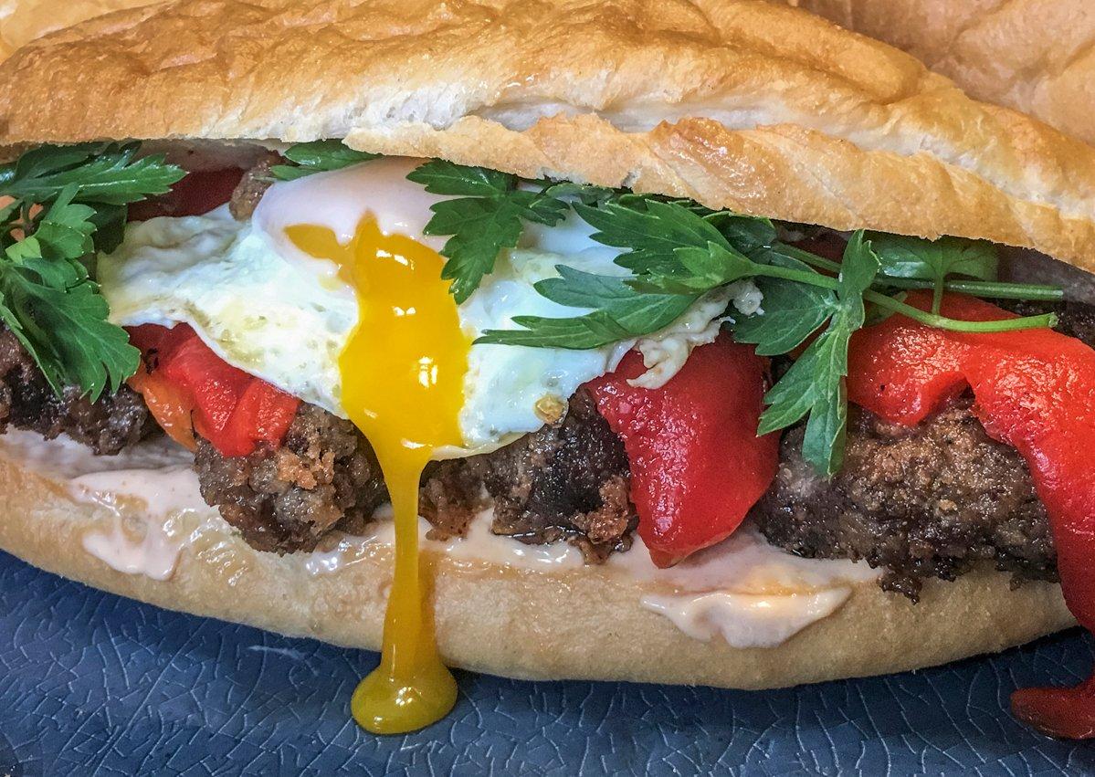 Top the marinated and fried backstrap with a fried egg, roasted peppers and fresh herbs.