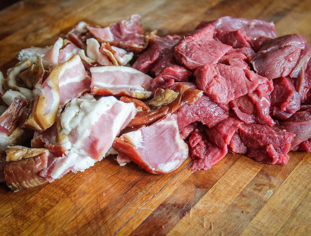Cut the bacon and the venison into small enough pieces to fit your grinder.