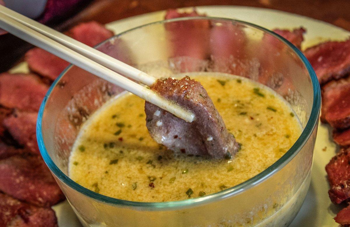 Use forks or chopsticks to dip the venison into the butter sauce.