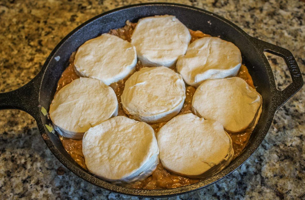 Top the filling with jumbo canned biscuits.