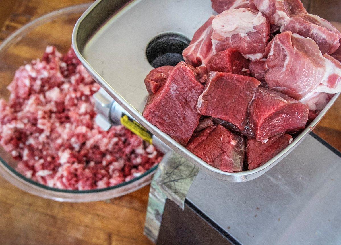 Use a stomper to safely feed meat down the throat of a grinder.