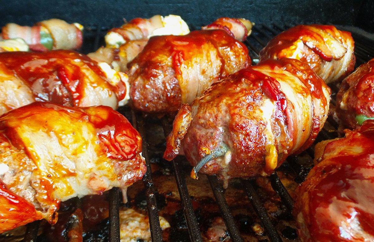 Our version of Armadillo Eggs are jalapenos stuffed with cheese, wrapped in ground venison and bacon and smoked till done.