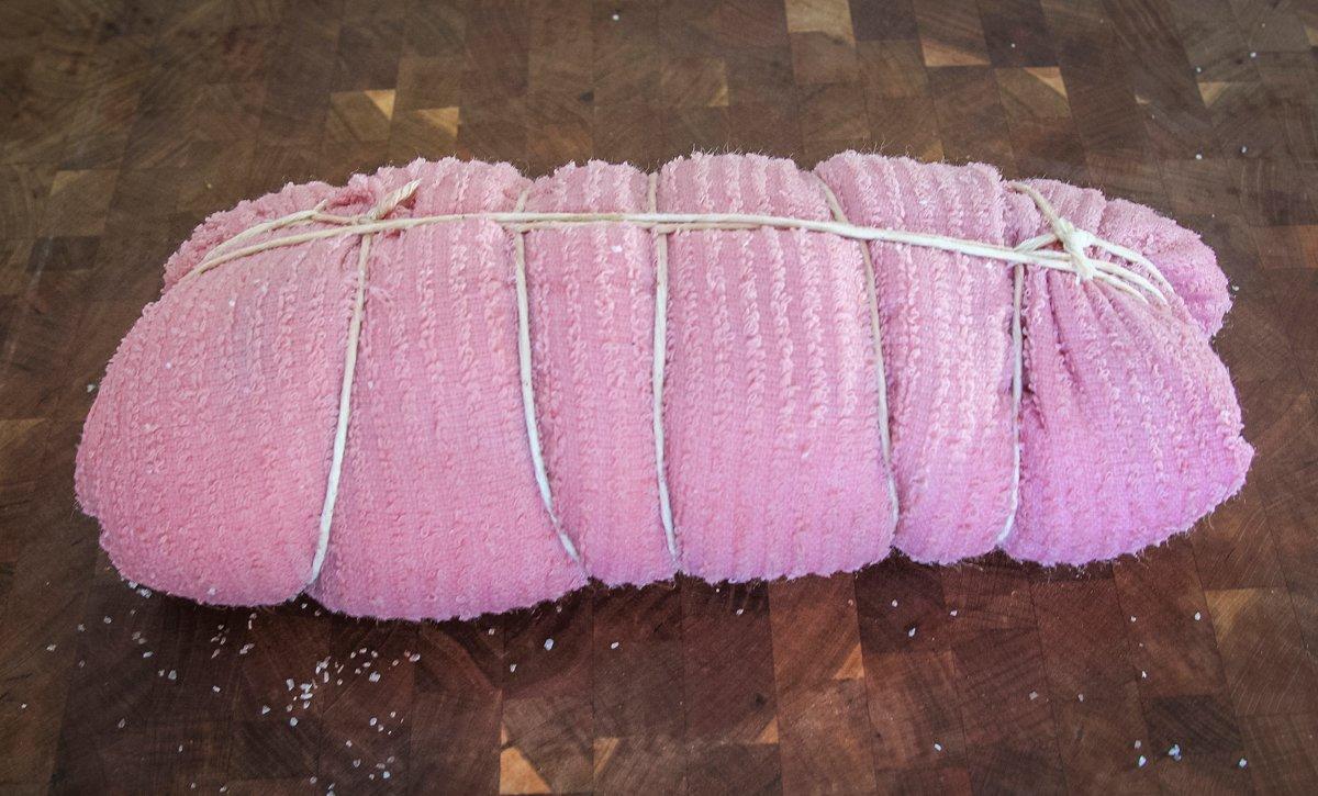 Wrap the backstrap tightly with the towel and tie with butcher's twine.