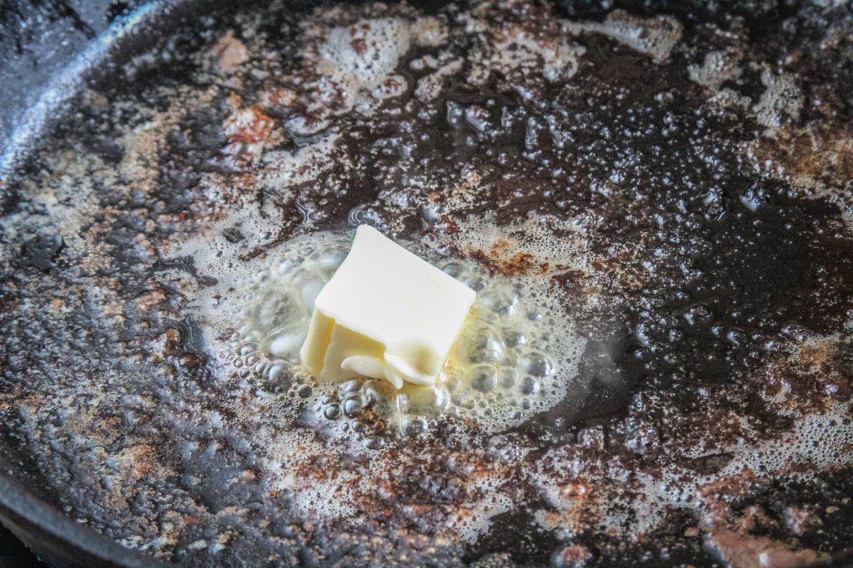 Add butter to a heavy cast iron pan and sear the steaks on all sides.