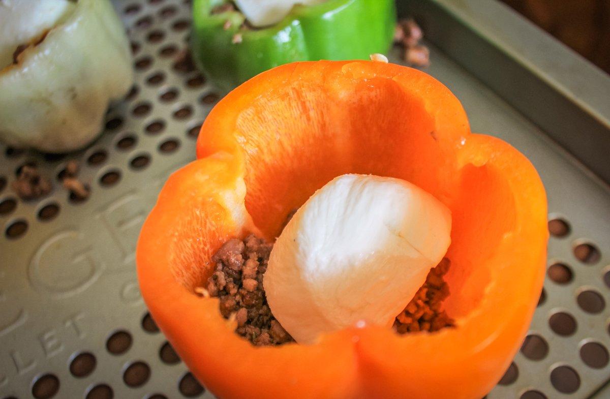 Spoon in some ground venison, then drop in a cube of cheese so that it is in the center of the pepper.