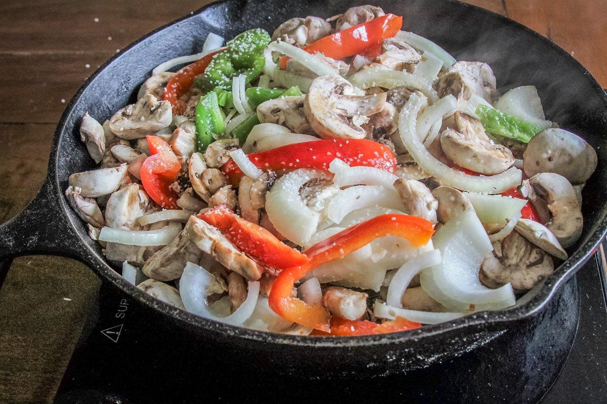 Cook the onions, peppers, and mushrooms until soft and cooked through.