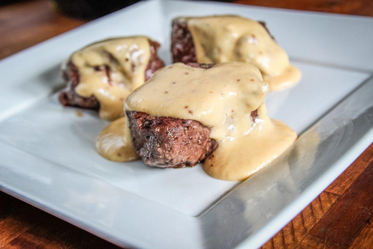 Backstrap medallions topped with beer cheese sauce.