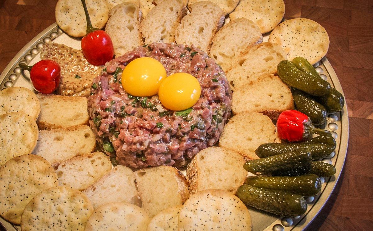 Serve the tartare topped with pasturized egg yolks for a silky texture.