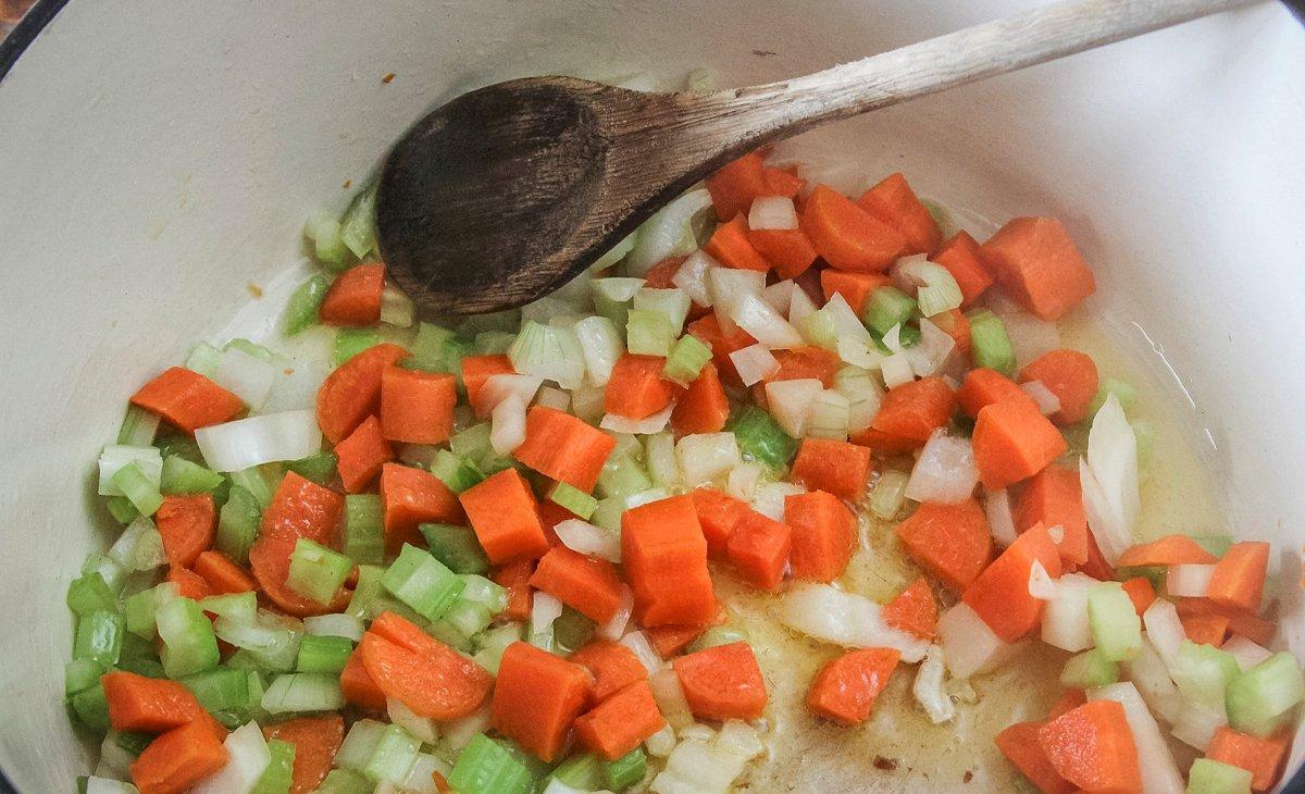 Start the soup by sauteing the onions, celery and carrots in oil. 