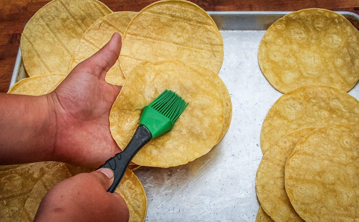 Brush both sides of the corn tortillas with oil and pop them in a preheated oven to soften.