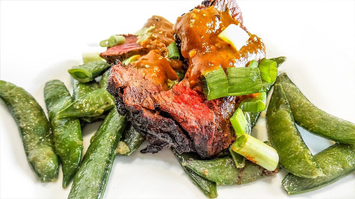 Serve the sliced venison over your favorite stir fried vegetables and top with the spicy peanut sauce.