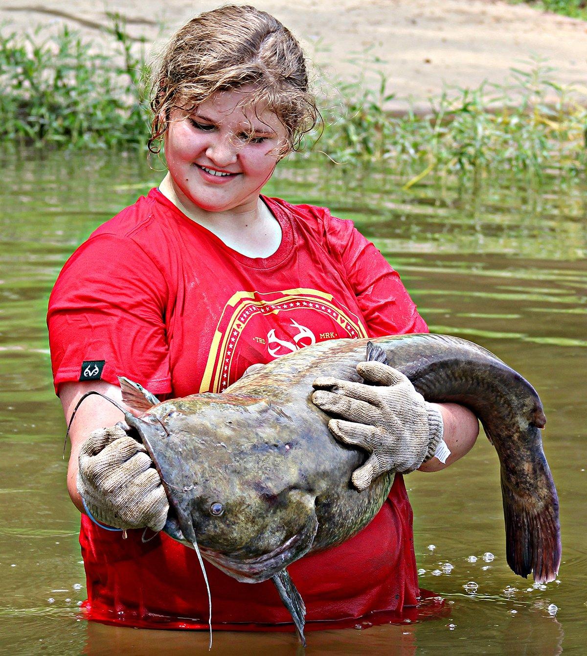 Michaela admires a nice flathead catfish before releasing it back to its watery hideaway. 