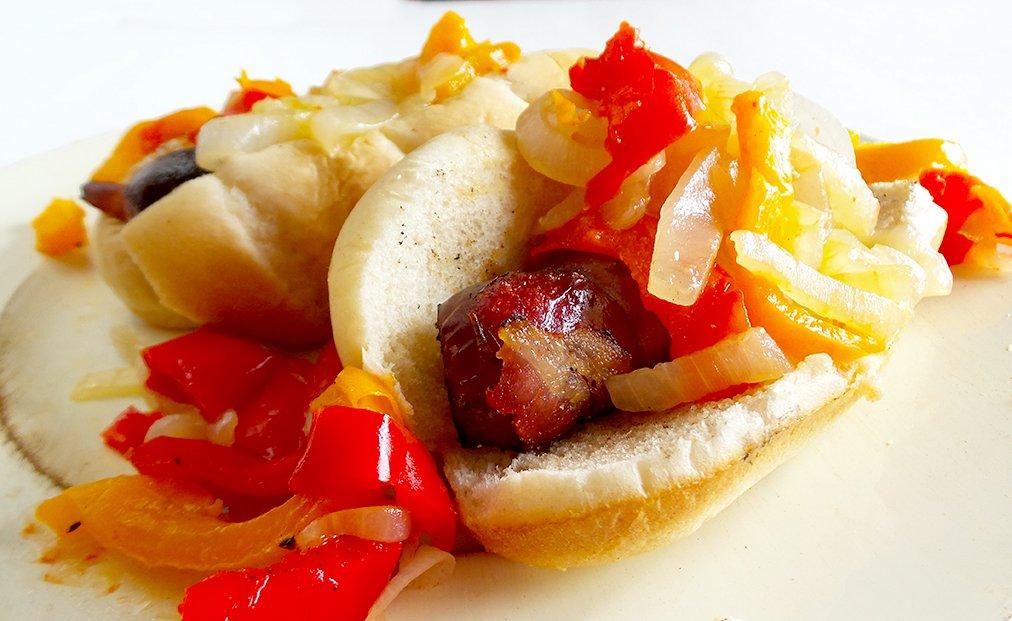 Plain grilled sausage is always good, but bacon wrapped and topped with onions and peppers really kick them up a notch.