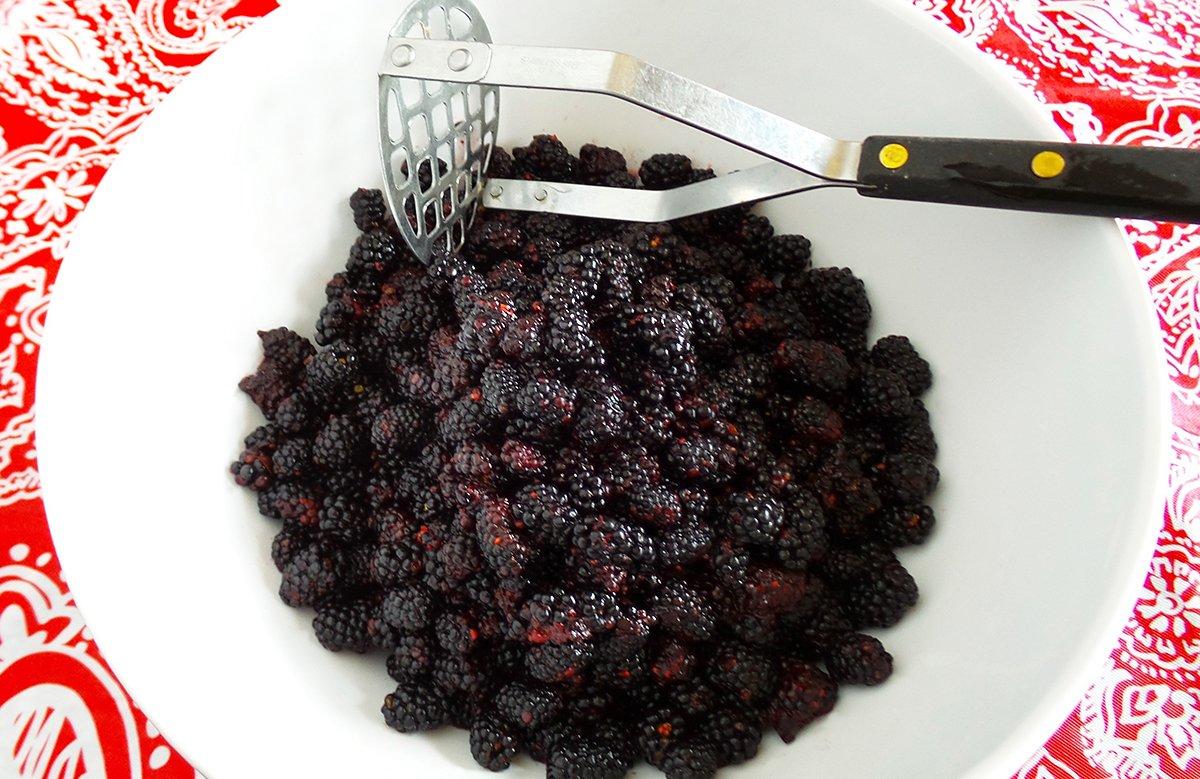 Smash the berries with a potato masher. Strain the seeds if you want smoother jam.