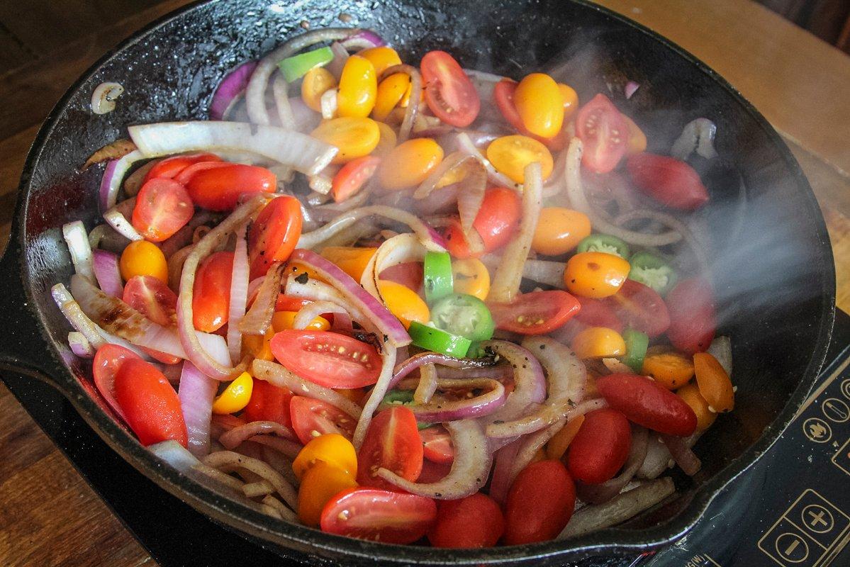 After the venison has browned, add the tomatoes, onions and peppers to the pan.
