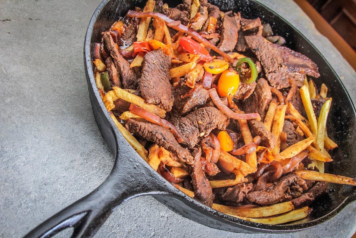 Once the other ingredients are nearly finished cooking, add the cooked fries to the skillet.