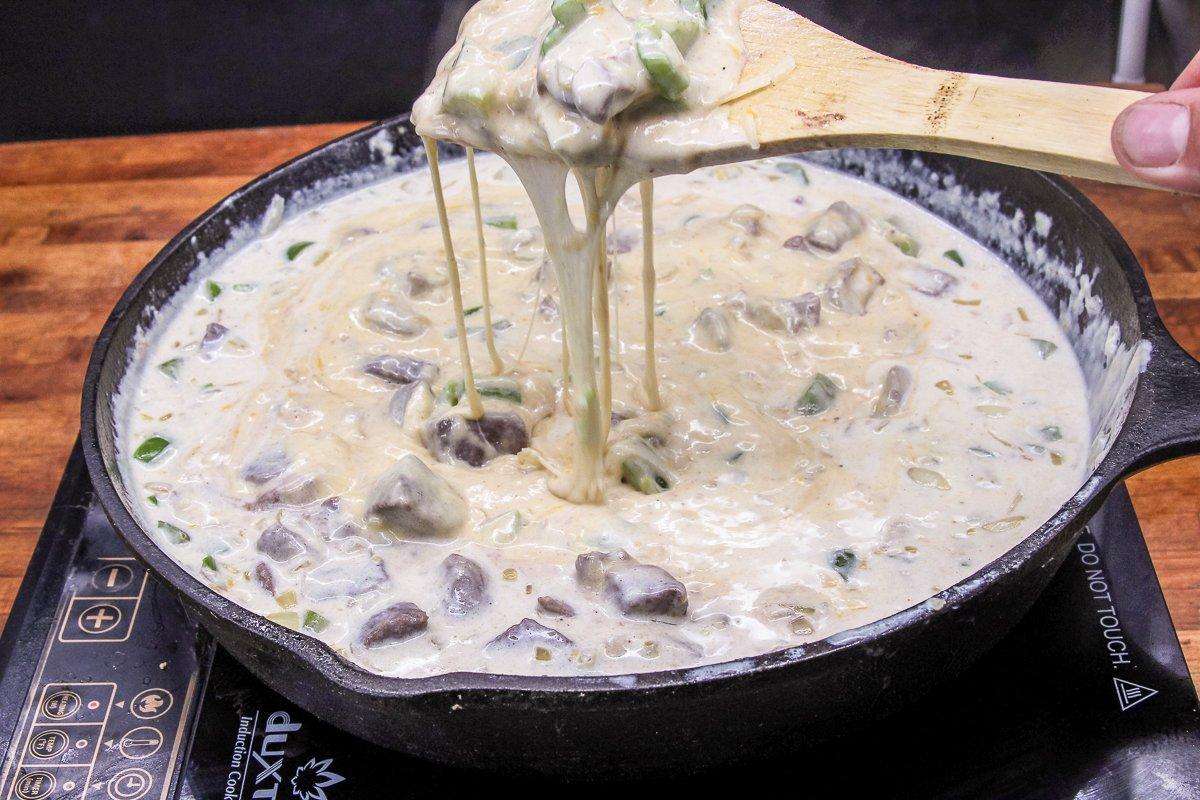 Stir the browned venison, peppers, and onions into the gooey, creamy sauce.