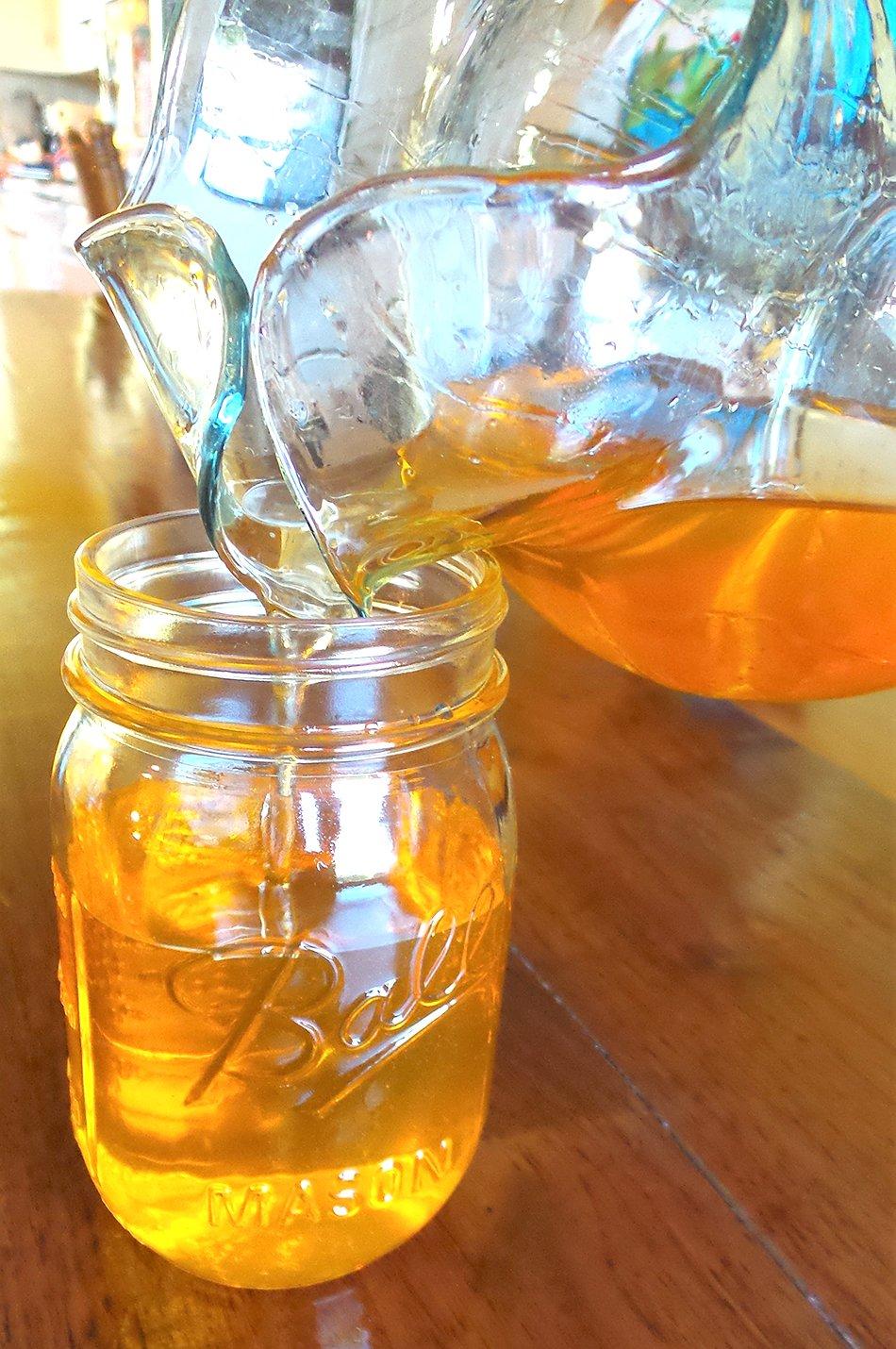 Filtering the warm fat into a pitcher makes filling the jars easy.