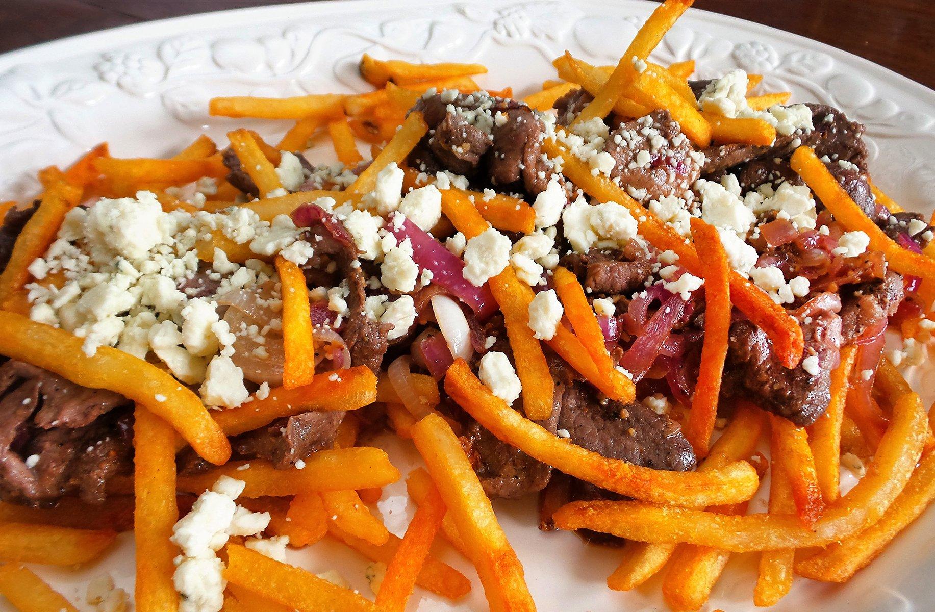 Top the fries with the steak and onions, then sprinkle on your favorite cheese.