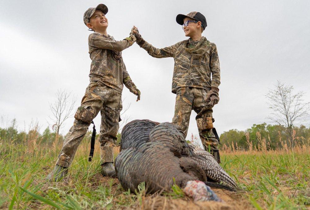 Young hunters celebrate a successful turkey hunt. © Realtree photo