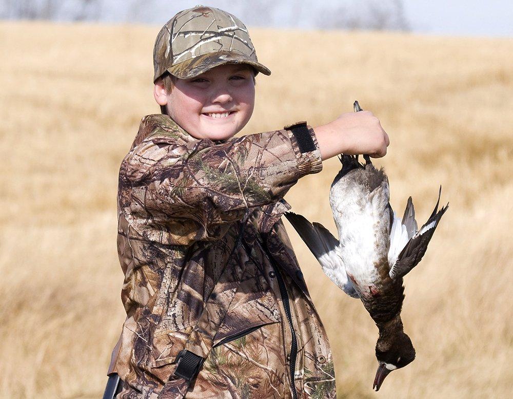 A new duck hunter sports a huge smile. Why would anyone criticize special youth hunts that create such opportunities? Photo © Steve Oehlenschlager/Shutterstock